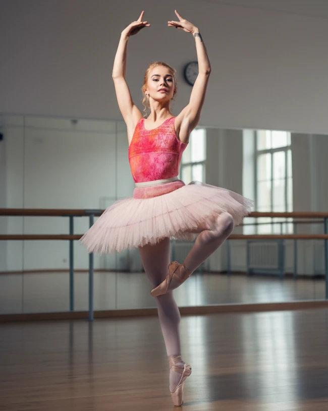 Bailarina de ballet en clase durante los cursos intensivos y master class de danza en Madrid en Semana Santa, en posición de retiré en puntas con los brazos en quinta posición.